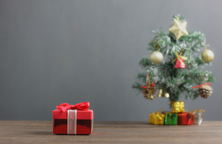 Red gift box and fir tree background.Variety objects on modern rustic wooden at home office desk.Many items is sign of winter season.Merry Christmas & Happy new year concept.Free space creative text.の写真素材