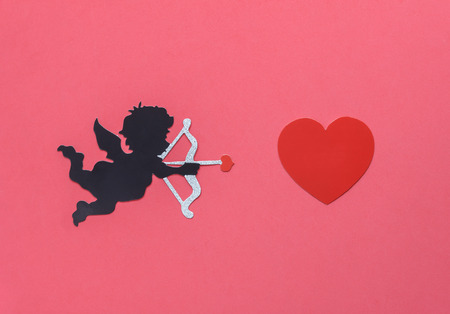 Flat lay aerial image of sign of valentines 's day background concept.DIY photo booth props the cupid shooting arrow to red heart on modern rustic pink wallpaper at home office desk studio.pastel toneの写真素材