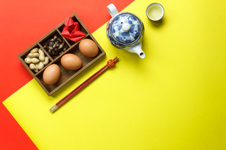 Above view of accessories Lunar & Chinese New Year holiday background concept.Free space for mock up & template design.Difference objects on modern rustic red & yellow paper at table.pastel tone.