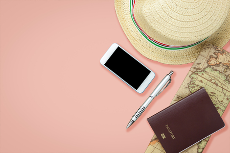 Mobile phone and passport with many item in vacation season on pink paper.の写真素材