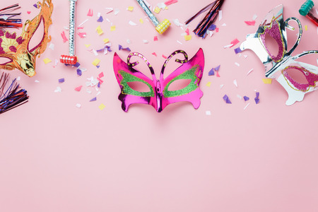 Table top view aerial image of beautiful colorful carnival mask or photo booth prop background.Flat lay object on modern rustic pink wallpaper at  office desk studio.space for creative design mock up.の写真素材