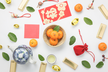 Top view aerial image shot of arrangement decoration Chinese new year & lunar new year holiday background concept.Flat lay fresh orange with food & drink on modern white wooden at home office desk.