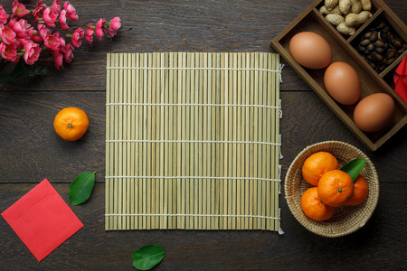 Flat lay aerial image of accessories Lunar New Year & Chinese New Year holiday background concept.Space for mock up & template.Top view objects on modern rustic brown wooden at home office desk.の写真素材