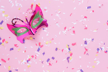 Table top view aerial image of beautiful colorful carnival mask or photo booth props background.Flat lay objects on modern rustic pink wallpaper at office desk studio.space for creative mock up.の写真素材