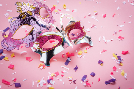 Table top view aerial image of beautiful couple carnival mask background.Flat lay essential accessory on modern rustic pink wallpaper at home office desk studio. Copy space for creative design text.の写真素材