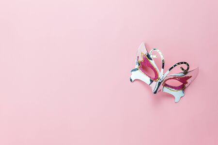 Table top view aerial image of beautiful silver carnival mask or photo booth prop background.accessory man fashion on modern rustic pink wallpaper at office desk.space for creative design text.の写真素材