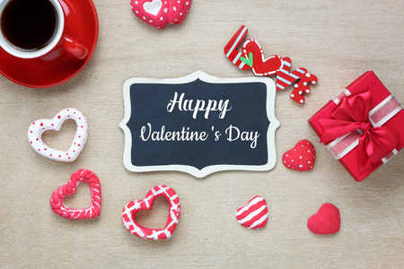 Table top view aerial image of decoration valentine's day background concept.Flat lay arrangement of blank space blackboard & essential items on modern rustic white wooden for mock up creative designの写真素材