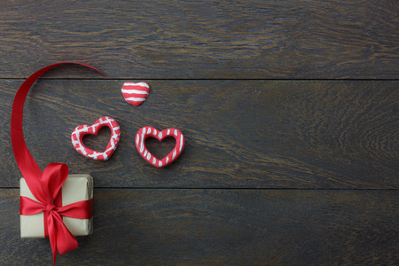 Table top view image of decoration valentine's day background concept.Flat lay heart shape and essential symbol love season with gift box on modern rustic brown wooden at home office desk studio.の写真素材