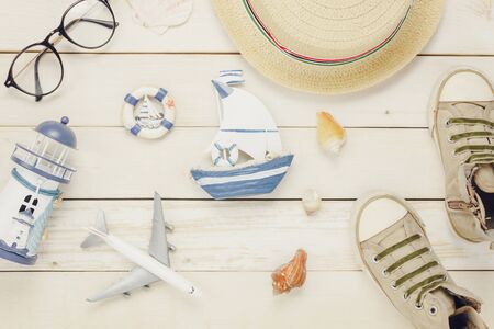 Table top view aerial image accessories to travel beach in summer background.Flat lay clothing with sign decoration of season on modern rustic white wooden at home office desk studio.Holiday concept.の写真素材