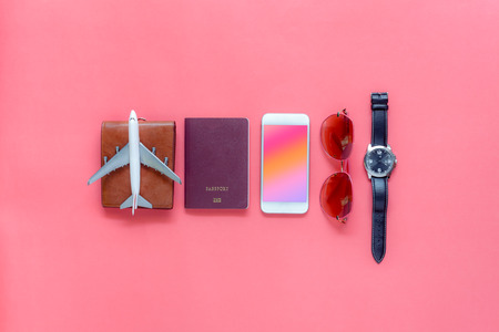 Flat lay image of accessory clothing man or women to plan travel in holiday background concept.Mobile phone & passport with many item in vacation season.Table top view several object on pink paper.の写真素材