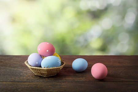 Shot of decoration Happy Easter holiday background concept.Arrangement bunny eggs on the modern rustic brown wooden table at home office desk with green nature backdrop.Negative space for creative.の写真素材