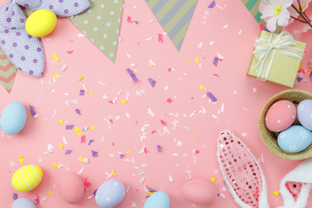 Table top view shot of arrangement decoration Happy Easter holiday background concept.Flat lay colorful bunny egg with accessory to celebration on modern rustic pink pastel paper at home office desk.の写真素材