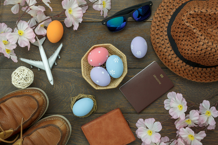 Table top view shot of decoration Happy Easter holiday background concept.Flat lay essential objects plan to travel vacation on modern brown wooden at office desk. Accessory for traveler to trip.の写真素材