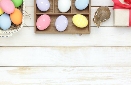 Top view shot of arrangement decoration Happy Easter holiday background concept.Flat lay colorful Easter egg with tulip flower and rabbit bunny on modern white wooden at office desk.space for mock upの写真素材
