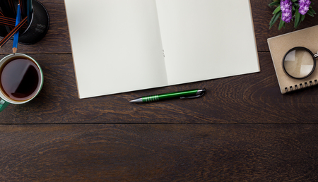 Table top view aerial image stationary on office desk background concept.Flat lay objects the cup of black coffee with essential accessory & tree plant.Items on modern brown wooden at home studio.の写真素材