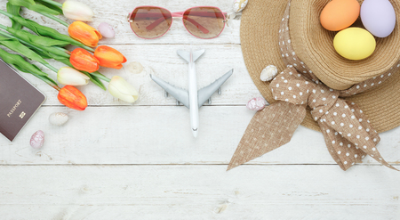 Table top view shot of decoration Happy Easter holiday background concept.Flat lay essential women objects plan to travel vacation on modern white wooden at office desk.Accessory for traveler to trip.の写真素材