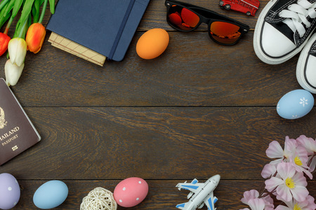 Top view shot of arrangement decoration Happy Easter holiday background concept.Flat lay colorful Easter egg with tulip flower and rabbit bunny on modern brown wooden at office desk.space for mock upの写真素材
