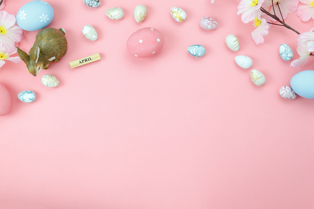 Table top view shot of arrangement decoration Happy Easter holiday background concept.Flat lay colorful bunny egg with flower and rabbit doll on modern rustic pink paper at home office desk with spaceの写真素材