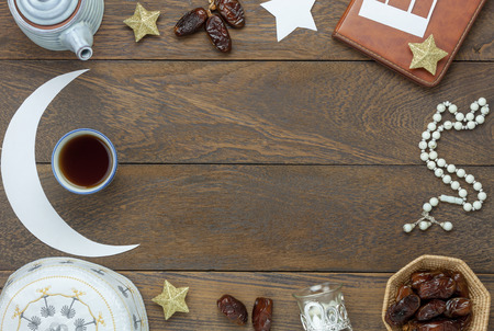 Table top view aerial image of decoration Ramadan Kareem holiday background.Flat lay date in wood basket with white rosary & decor.Objects on modern rustic brown wood at office desk with copy space.の写真素材