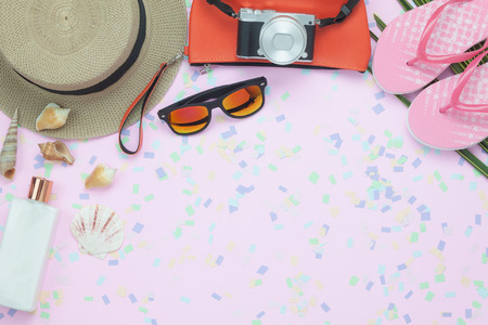Table top view aerial image of woman clothing for travel beach or sea in summer holiday season background concept.Flat lay essential objects on modern pink paper with confetti and copy space.の写真素材