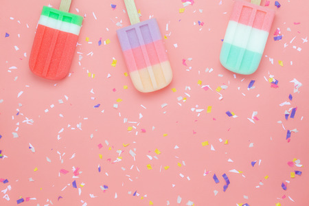 Table top view aerial image of food for summer holiday background concept.Flat lay arrangement variety ice cream pop stick on modern rustic pink paper wallpaper at office desk.Pastel tone design.の写真素材