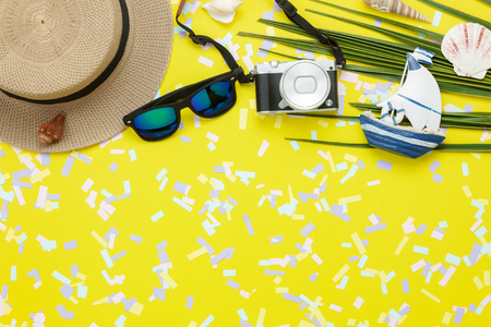 Table top view aerial image of items to travel summer holiday background concept.Flat lay essentials accessories for travel to beach trip.Fashion sun glasses with camera & hat on green coconut leaf.の写真素材