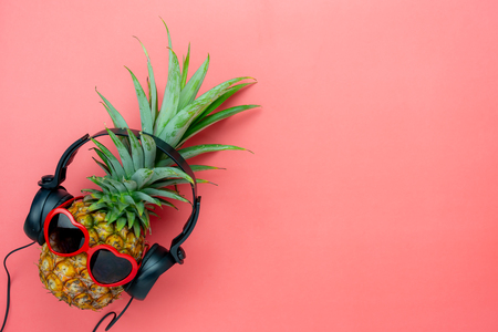 Table top view aerial image of food for summer holiday season & music background concept.Flat lay object the pineapple listening radio by black headphone for sign of seasonal on modern pink paper.の写真素材