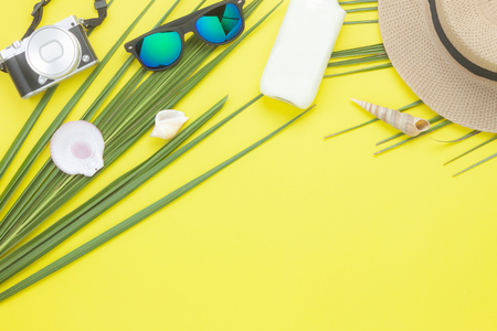 Table top view aerial image of fashion to travel in summer holiday background.Flat lay accessories clothing for traveler.Camera & sunglasses on modern rustic yellow paper wallpaper.Space for content.の写真素材