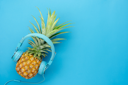 Table top view aerial image of food for summer holiday season & music background concept.Flat lay object the pineapple listening radio by blue headphone for sign of seasonal on modern paper.の写真素材