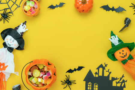 Table top view aerial image of decoration Happy Halloween day background concept.Flat lay accessories essential object to party the pumpkin & sweet candy on yellow paper.Space for creative design.の写真素材