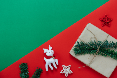 Table top view of Merry Christmas decorations & Happy new year ornaments concept.Flat lay essential difference objects reindeer & gift box on modern red & green paper background at home office desk.の写真素材