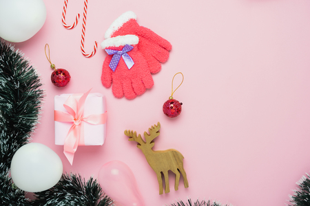 Table top view of Merry Christmas decorations & Happy new year ornaments concept.Flat lay essential objects the reindeer & gift box on modern rustic pink paper background at home studio office desk.の写真素材