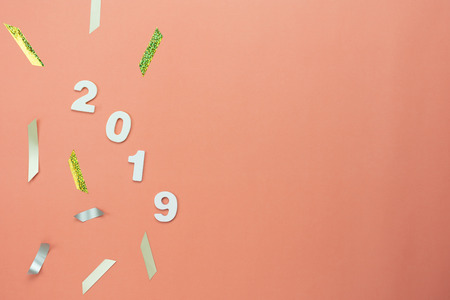 Table top view of Merry Christmas decorations & Happy new year 2019 ornaments concept.Flat lay essential difference objects text number with silver & golden confetti on modern pink paper background.の写真素材