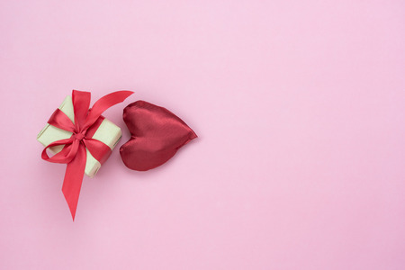 Table top view aerial image of decoration valentine's day background concept.Flat lay essential items red heart & gift box on modern rustic pink paper.blank space for mock up creative design text.の写真素材