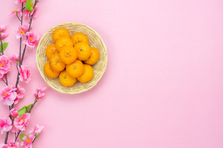 Table top view decoration or ornament the Lunar New Year & Chinese New Year concept background.Flat lay object the orange in wooden basket with cherry blossom on pink paper.creative design for mock upの写真素材
