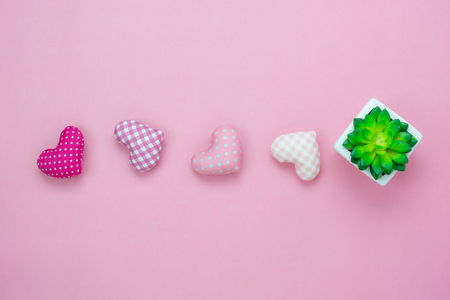 Table top view aerial image of decoration valentine's day or earth day background concept.Flat lay essential items tree pot and colorful love shape on modern pink paper.blank space for mock up.の写真素材