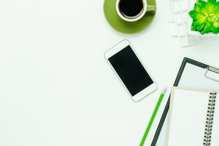 Table top view aerial image of accessories office desk background concept.Flat lay of variety object the mobile phone & tree and coffee with notebook on modern rustic white wooden with copy space.の写真素材