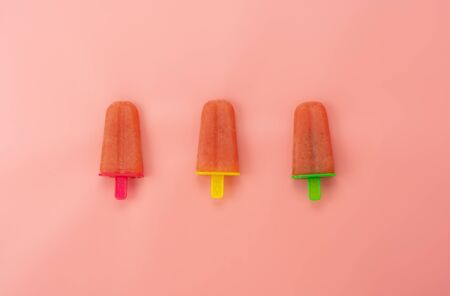 Table top view aerial image of food for summer holiday background concept.Flat lay watermelon ice cream pop stick by homemade on modern rustic pink paper wallpaper.Pattern with minimal style pastel.の写真素材