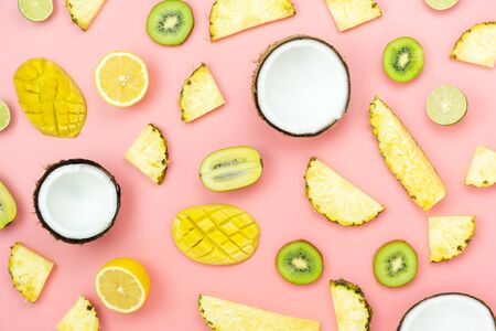Table top view fruit tropical with spring summer holiday & vacation  background concept.Arrangement sliced various pineapple kiwi mango lemon and lime coconut on  pink paper.flat lay & pastel tone.の写真素材