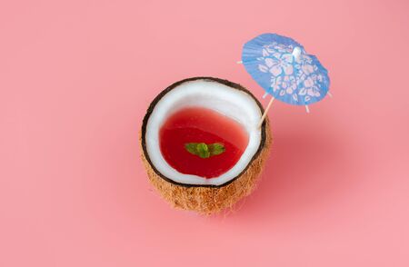 Fruit tropical with spring summer holiday & vacation background concept.Arrangement watermelon juice in sliced coconut & umbrella beach on modern pink paper.Minimal style with pastel tone design.の写真素材