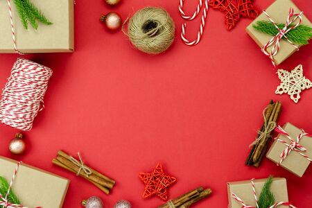 Table top view of Merry Christmas decorations & Happy new year ornaments concept.Flat lay essential difference objects gift box & fir tree on modern red paper background at home studio office desk.の写真素材