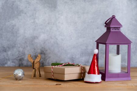 Accessories of Merry Christmas decorations & Happy new year ornaments concept.Gift box with lantern with reindeer object to party season on modern rustic brown & grey stone backdrop.space for design.の写真素材