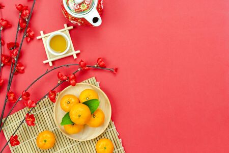 Flat lay cup of tea with  red pocket money and pink cherry flower on red paper.の写真素材