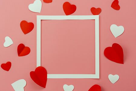 Table top view image of decoration valentine's day background concept.Flat lay arrangement of red shape & gift box with essential items on modern rustic pink paper with middle space for mock up designの写真素材