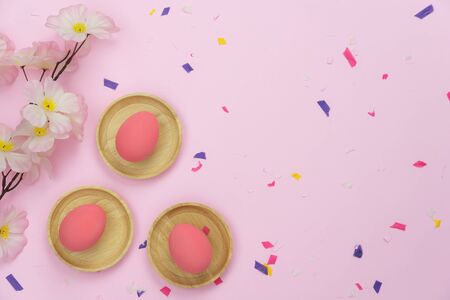 Top view shot of arrangement decoration Happy Easter holiday background concept.Flat lay colorful bunny eggs with confetti ornament on modern beautiful pink paper at office desk.Design pastel tone.の写真素材