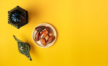 Table top view aerial image of decorations Ramadan Kareem holiday background.Flat lay date with aladdin lamp & arabic lantern.Halal meal set for fasting is obligatory for Muslim on grey cement.の写真素材