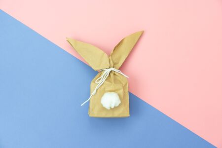 Top view shot of arrangement decoration Happy Easter holiday background concept.Flat lay minimalism paper bag same bunny or rabbit  for gift or present on modern pink paper at office desk.pastel tone.の写真素材