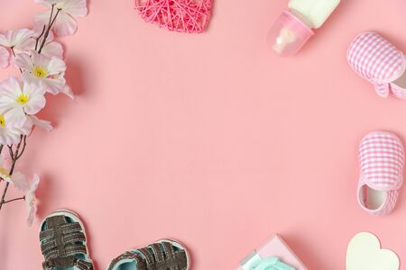 Top view aerial image of decoration Happy mothers day text holiday background concept.Flat lay gift box with baby shoes and love shape flower on modern beautiful pink paper.copy space for design.の写真素材