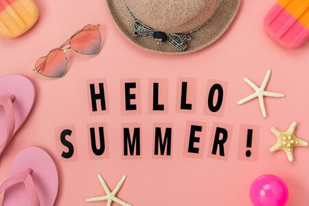 Table top view accessory of clothing women  plan to travel in Hello  summer word holiday background concept.Ice cream with many essential items hat & sandals flower, starfish, ball on pink paper.の写真素材