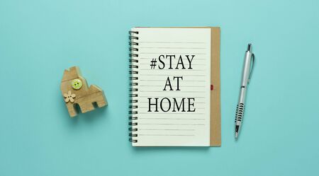 Table top view aerial image of accessories office desk for work from home with #STAY AT HOME work background concept. Flat lay of home toy & notebook and pen on blue paper. Healthcare for quarantine.の写真素材